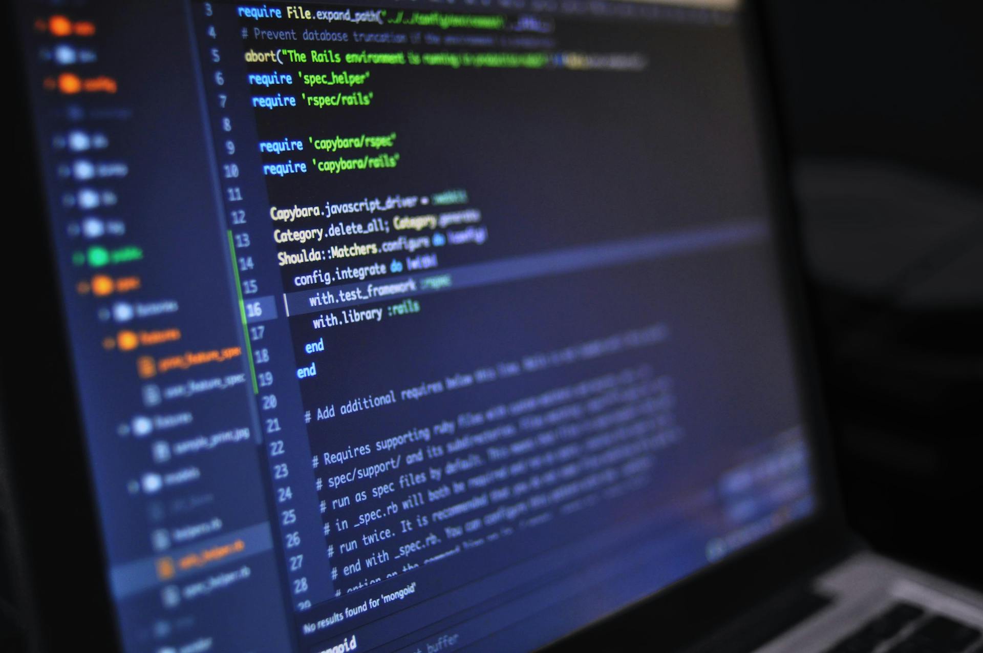 Laptop-Bildschirm leuchtet in einem dunklen Raum und zeigt Codezeilen