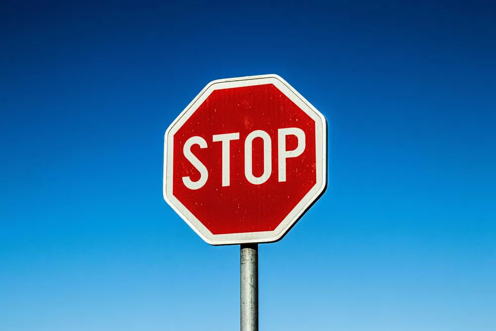 Red stop sign against a clear blue sky