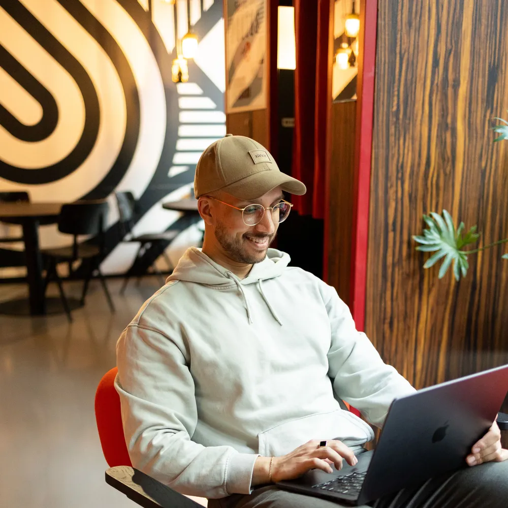 Dilshan Kelsen, Gründer von Webigo, arbeitet konzentriert an seinem Laptop.